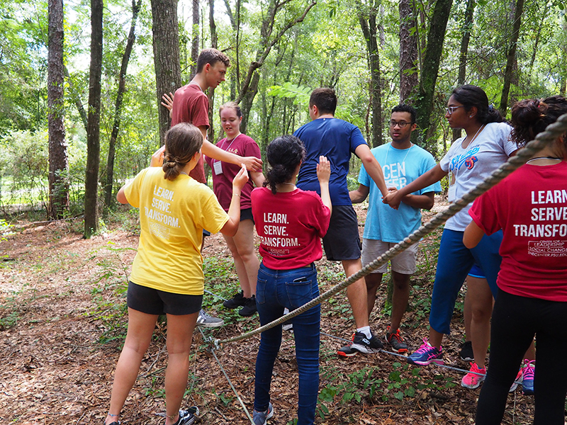 SLS student participants supporting each other through an obstacle course exercise.