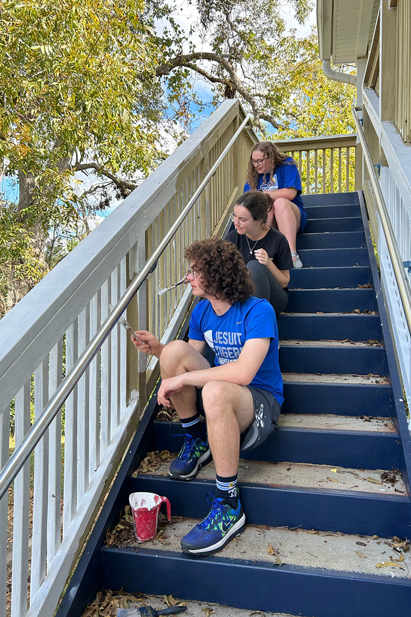 "Three Service Scholars paint a staircase"