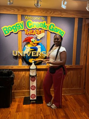 Student posing with the Camp Boggy Creek logo.