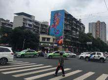 A woman crosses the street at a busy intersection