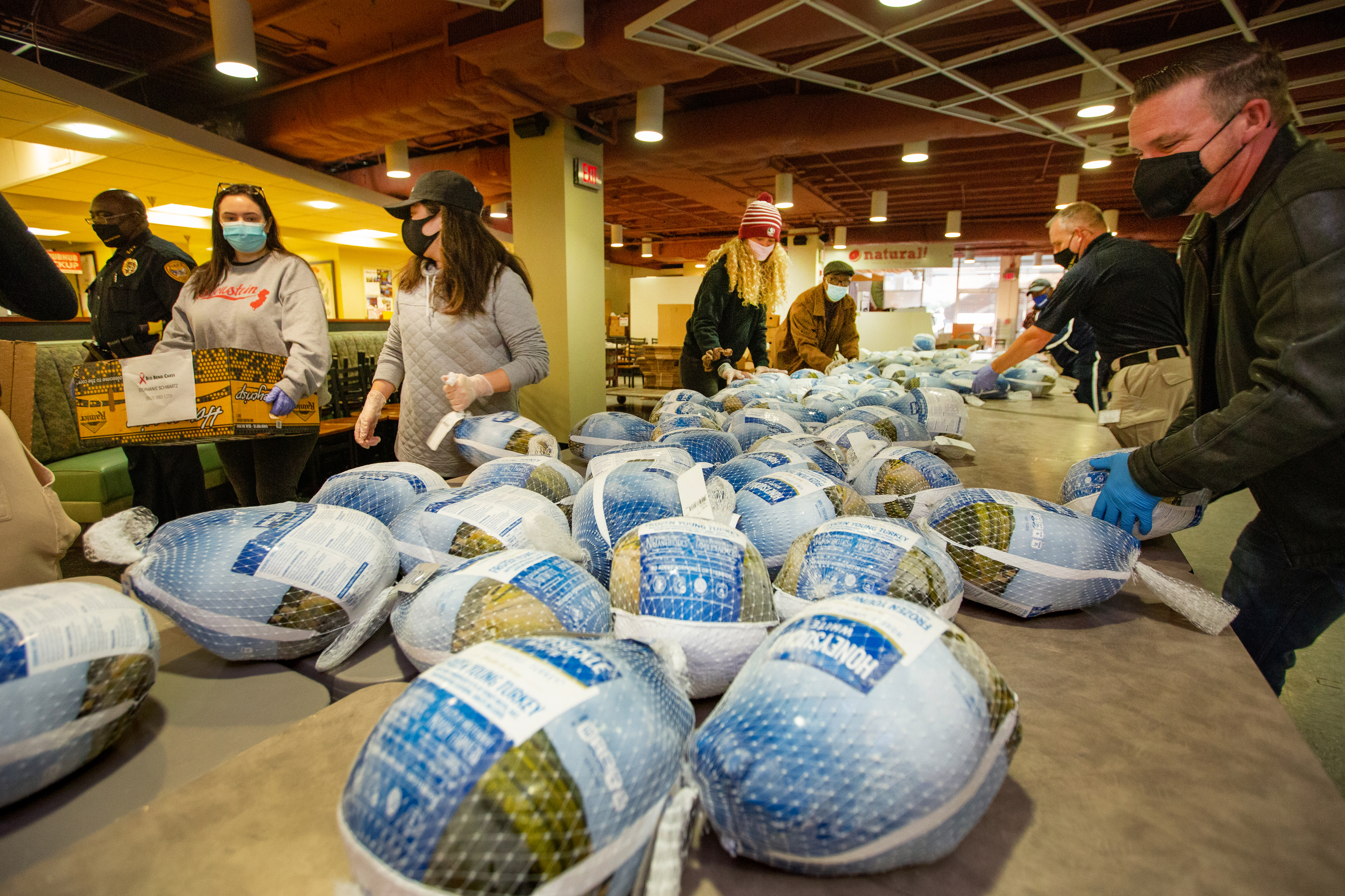 Multiple volunteers organize and prepare turkeys to be packed