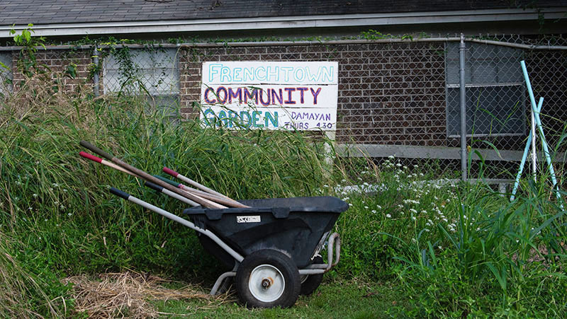 Frenchtown Community Garden sign hung on the fence within the garden.