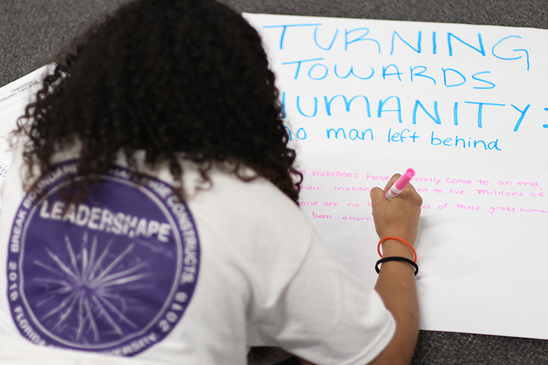 A Leadershape participant writing on a poster paper.