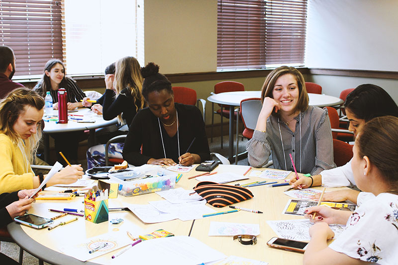 MLS participants socializing and coloring as part of a group activity
