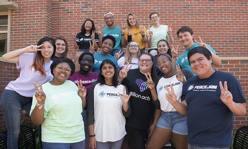 PeaceJam cohort holding up peace signs.