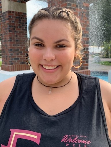 Maria Flores, Florida State University senior and PeaceJam Southeast intern, poses in front of a fountain on campus.