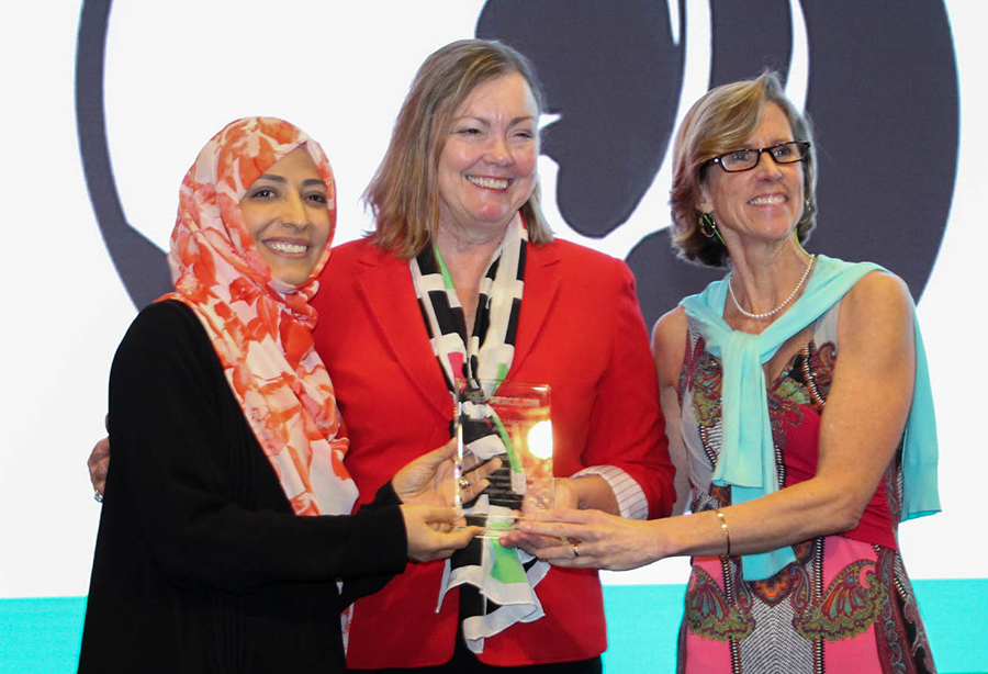 Nobel Peace Laureate Tawakkol Karman and PeaceJam Foundation executive director Kate Cumbo present Provost Sally McRorie (center) with the PeaceJam's inaugural Innovative Leadership Award.