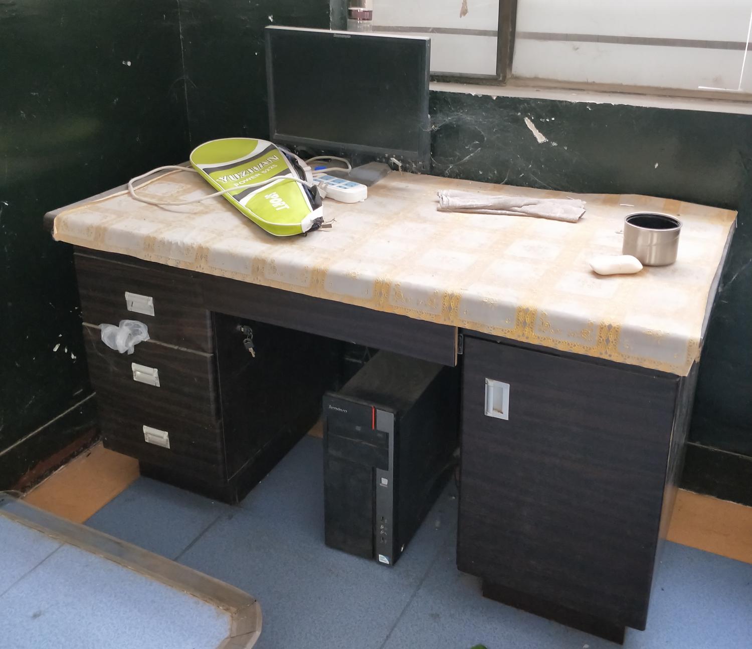 A computer sits unused on a desk in an elementary school classroom