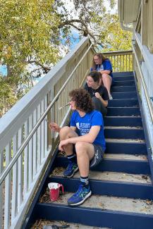 Three students paint a staircase during a service project with Habitat for Humanity of the Big Bend.