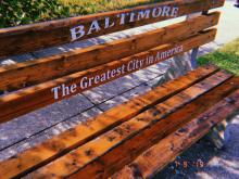 The bench from my bus stop, reading "Baltimore - The Greatest City in America"