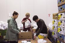 Three students sort food at Second Harvest of the Big Bend during a pre-remote community engagement program. 